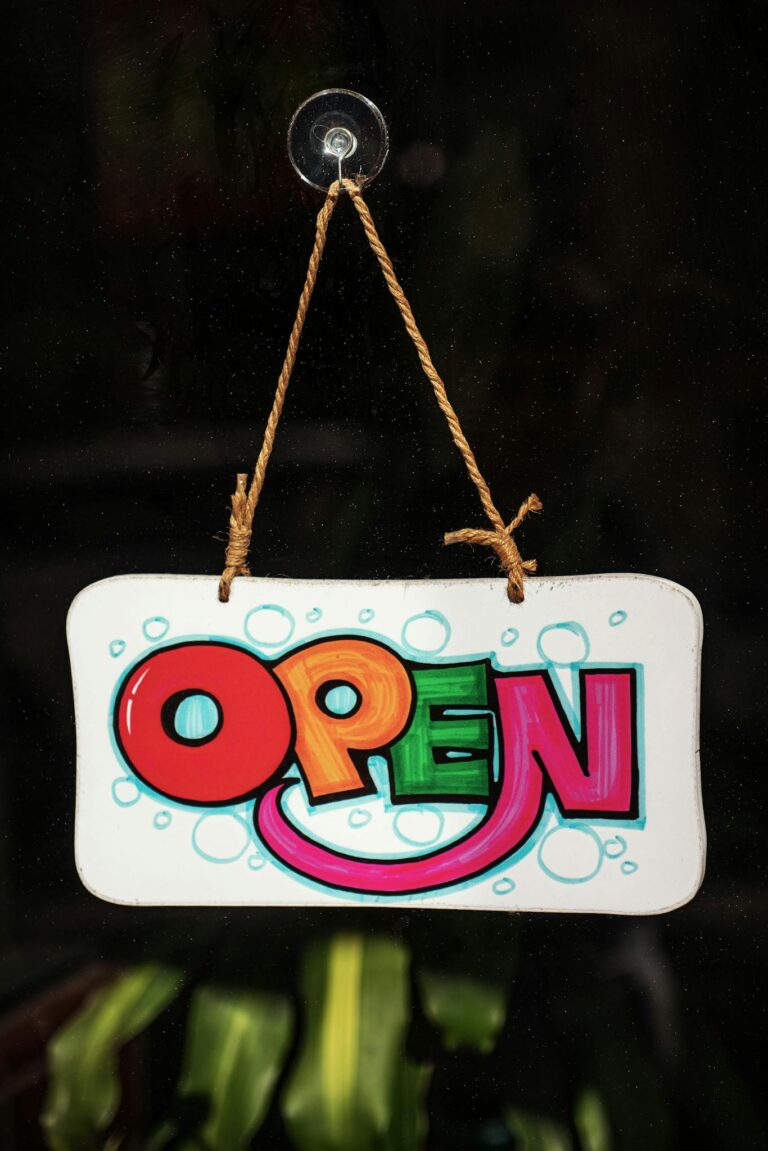 Vibrant and playful open sign hanging on a glass door, inviting visitors in.