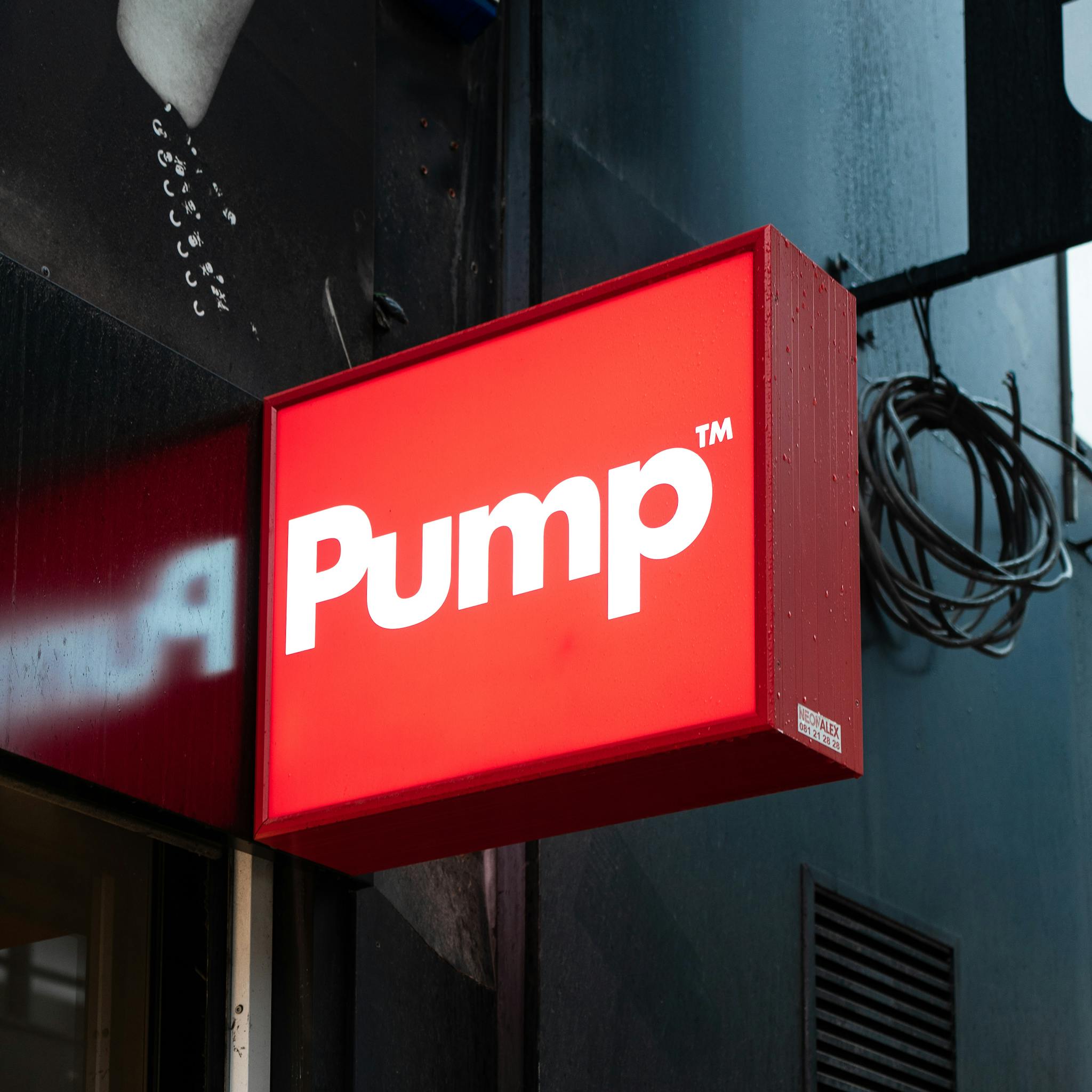 Vibrant red Pump sign on a storefront exterior in Brussels, Belgium.